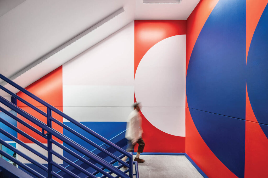 a stairwell with blue, red, and white graphic walls