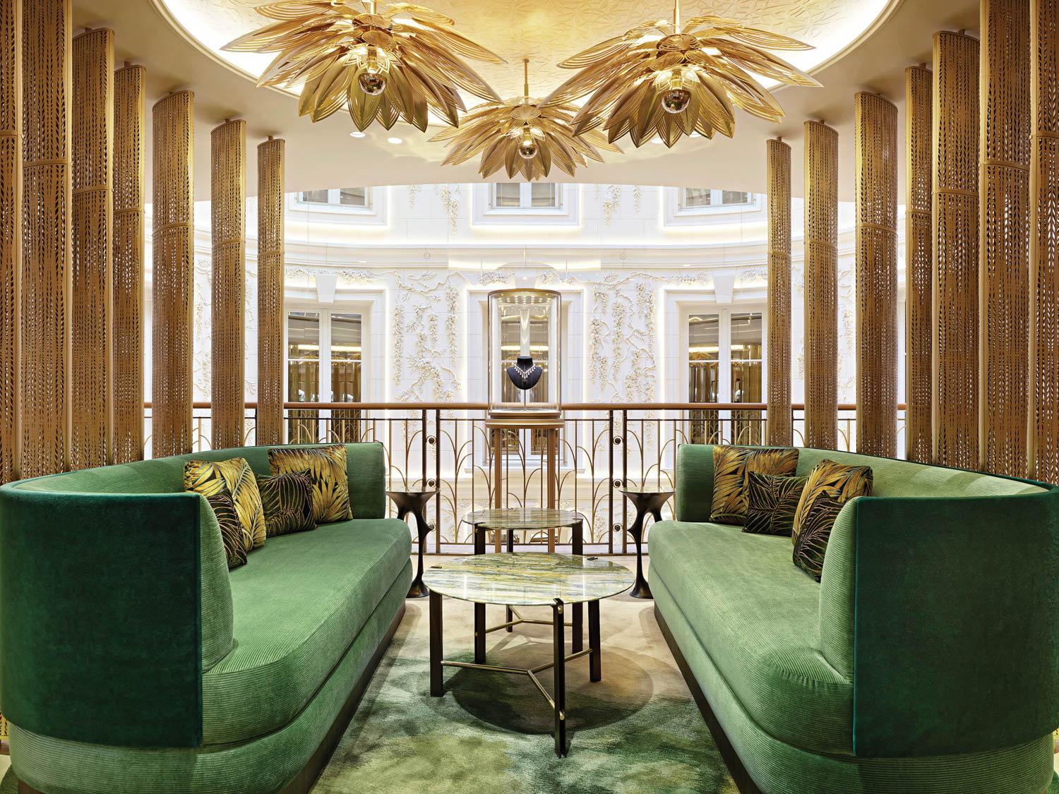 green sofas under a leaf-like gold chandeliers