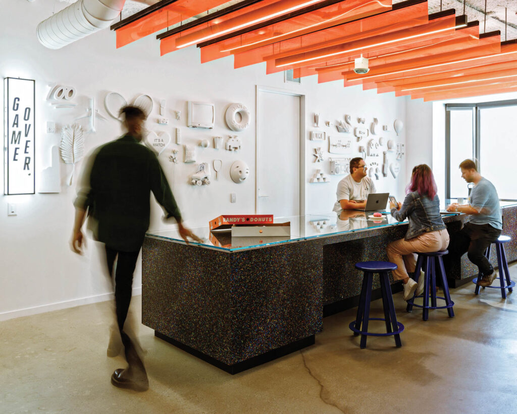 Employees gather around a desk at the Tinder office in L.A.