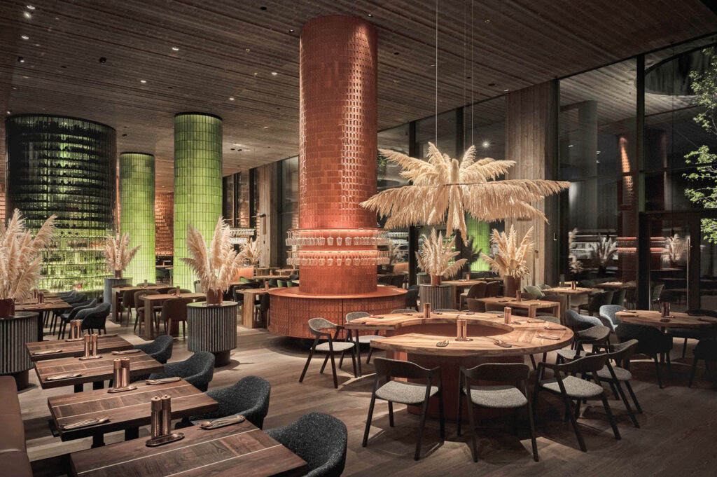 Columns wrapped in green and terracotta tile add pops of color to the restaurant